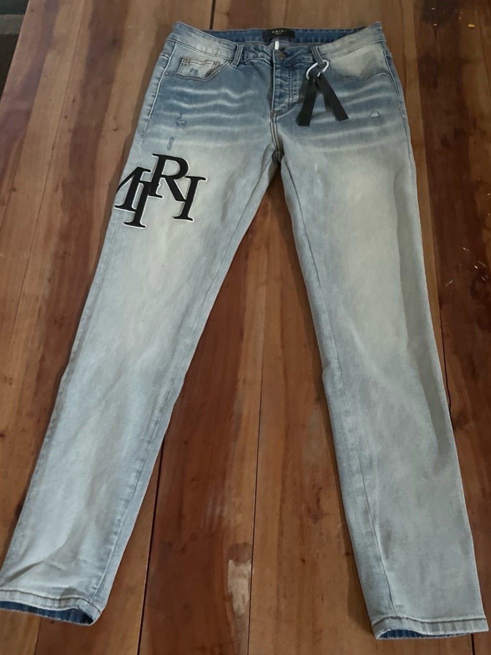 AMIRI Light Blue Skinny Jeans with Black Monogram Patch